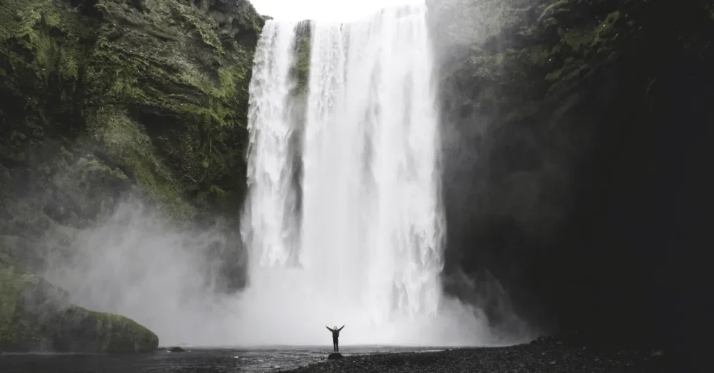 Man in front a Big Iceland Waterfall